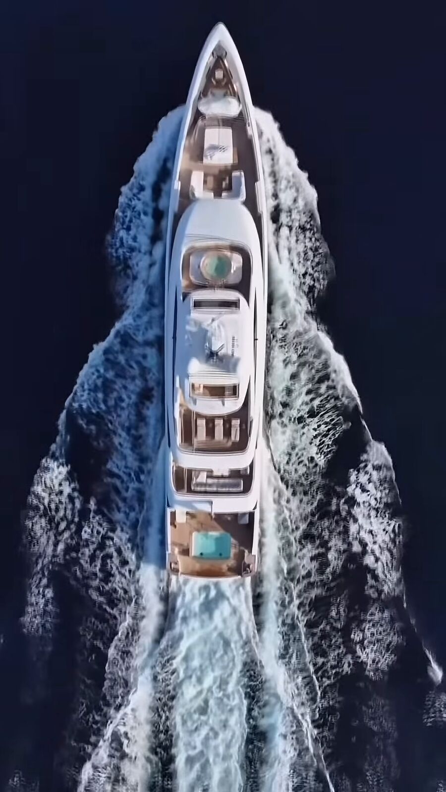 Yacht from above cutting a white wake